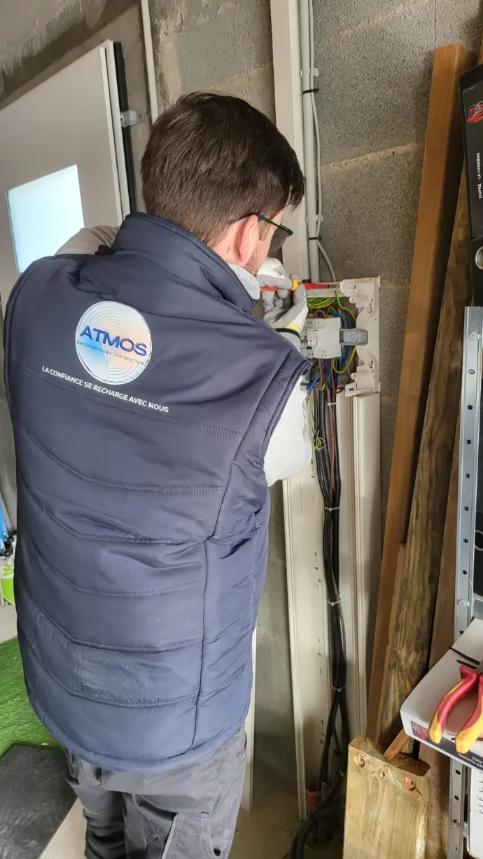 Technicien IRVE installant une borne au domicile d'un salarié Technicien IRVE installant une borne au domicile d'un salarié